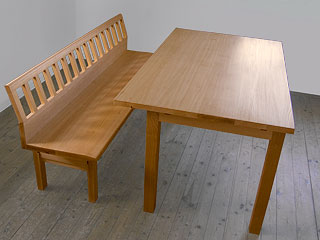 Tisch mit exzentrischer Tischplatte. Sitzbank.